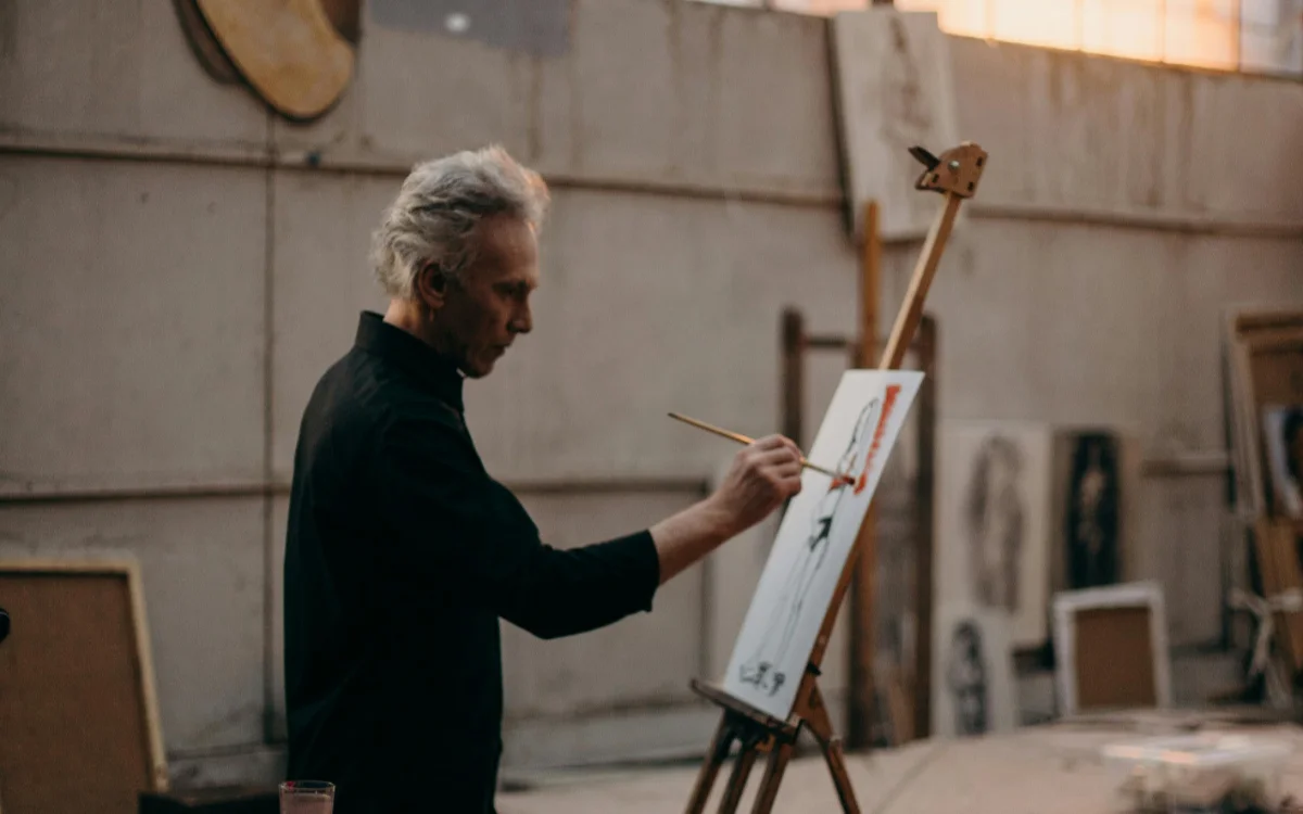 A Serious Man Painting On a White Cardboard