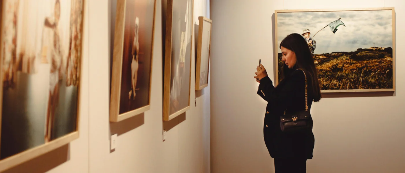 Artists and guests socializing among artworks at an exhibition
